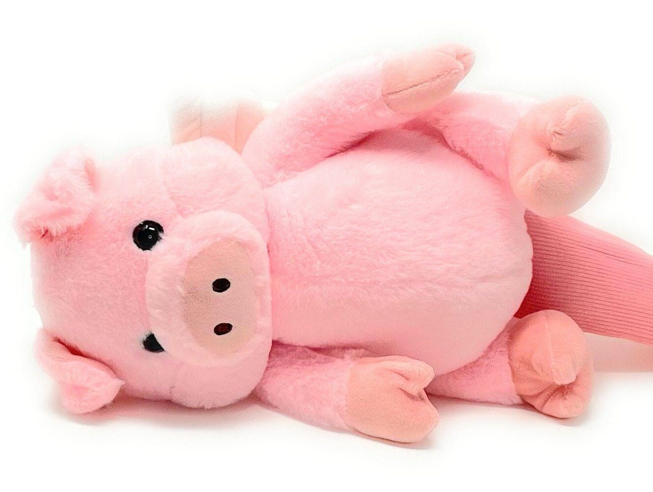 A pink stuffed pig laying on its back.