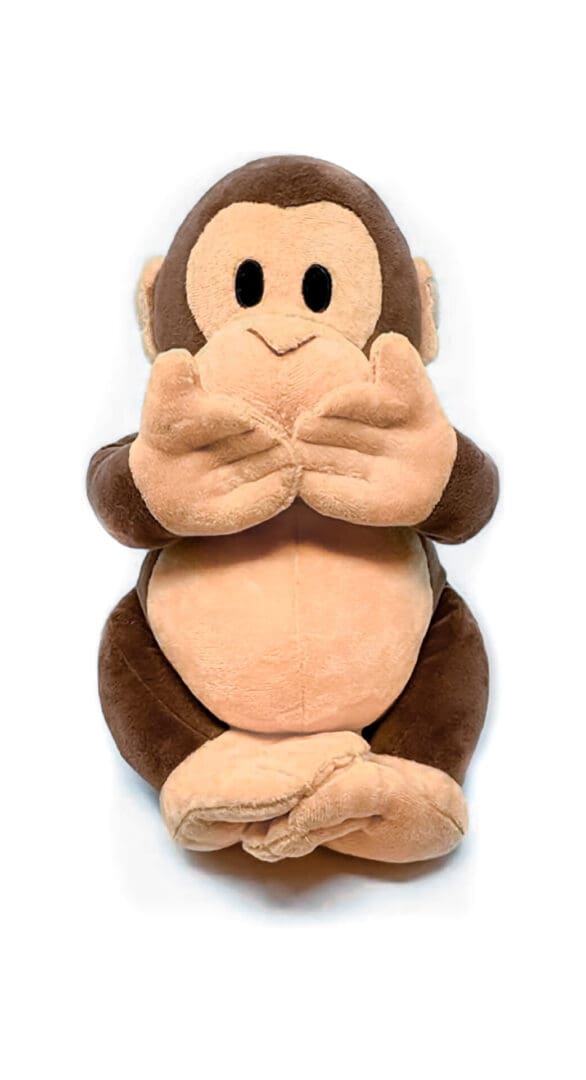 A stuffed monkey sitting on top of a white table.