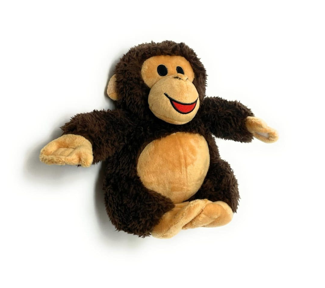 A stuffed monkey is laying down on its back.