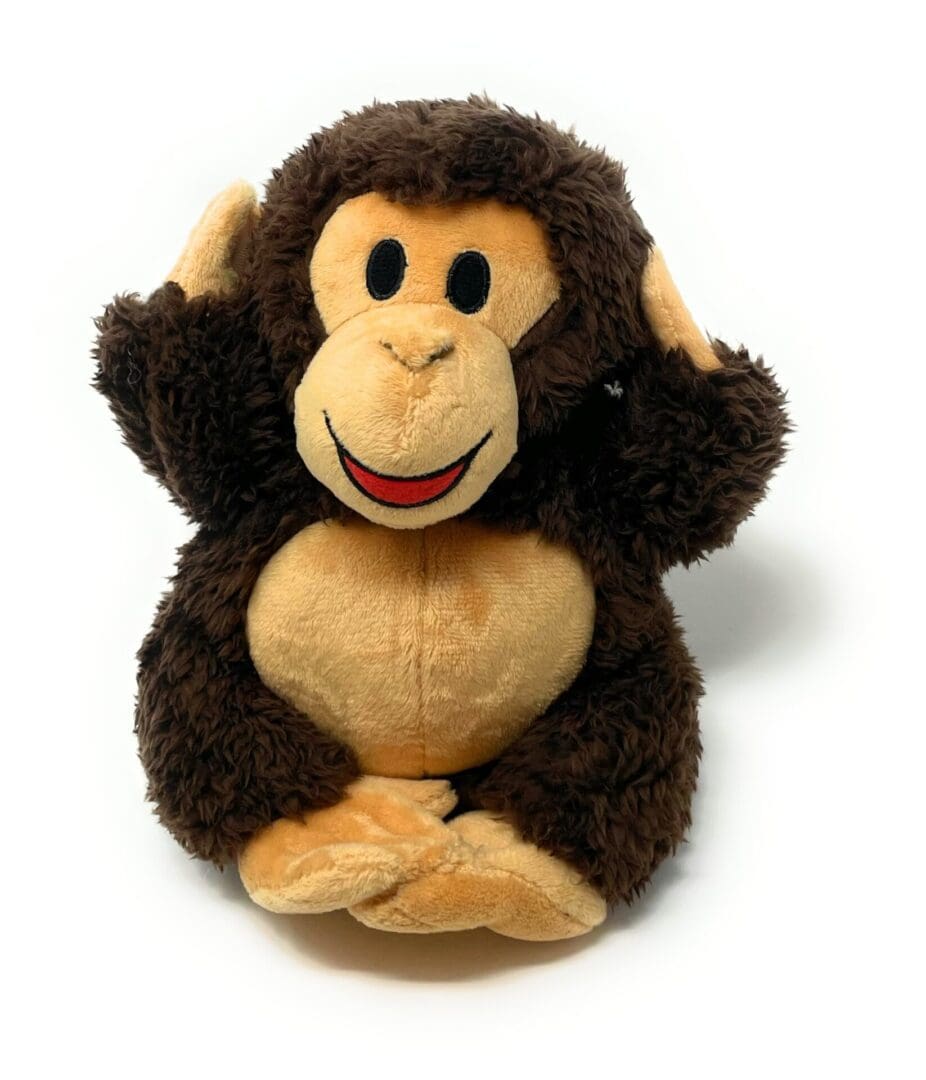 A stuffed monkey sitting on top of a white table.