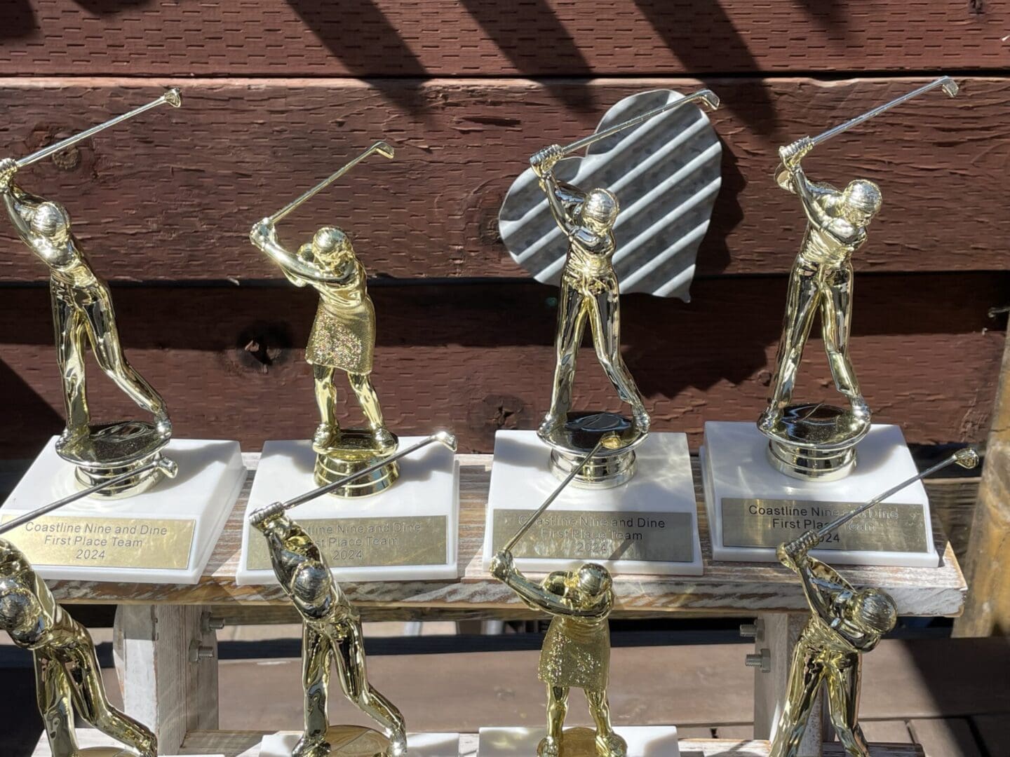 Gold golf trophy awards on shelf.