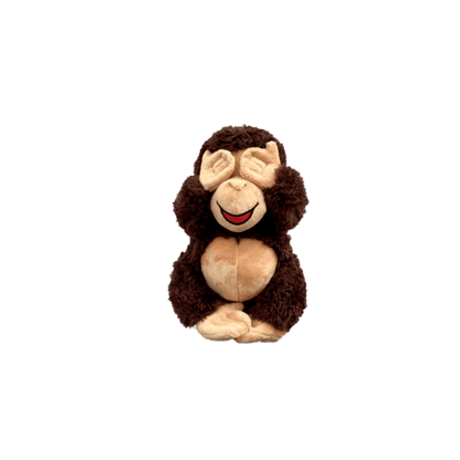 A stuffed monkey sitting on top of a green background.