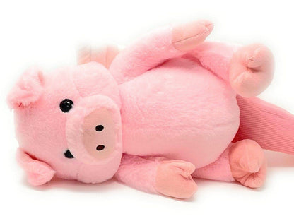 A pink stuffed pig laying on its back.