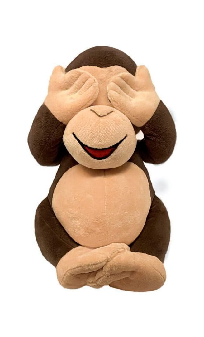 A stuffed monkey with hands over eyes