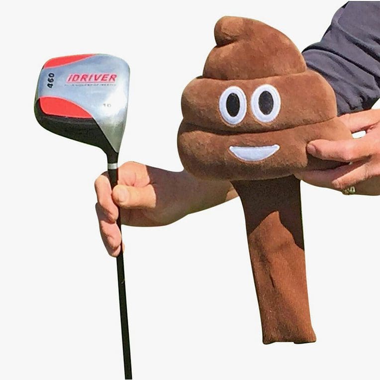 A person holding a golf club and a stuffed poop head.